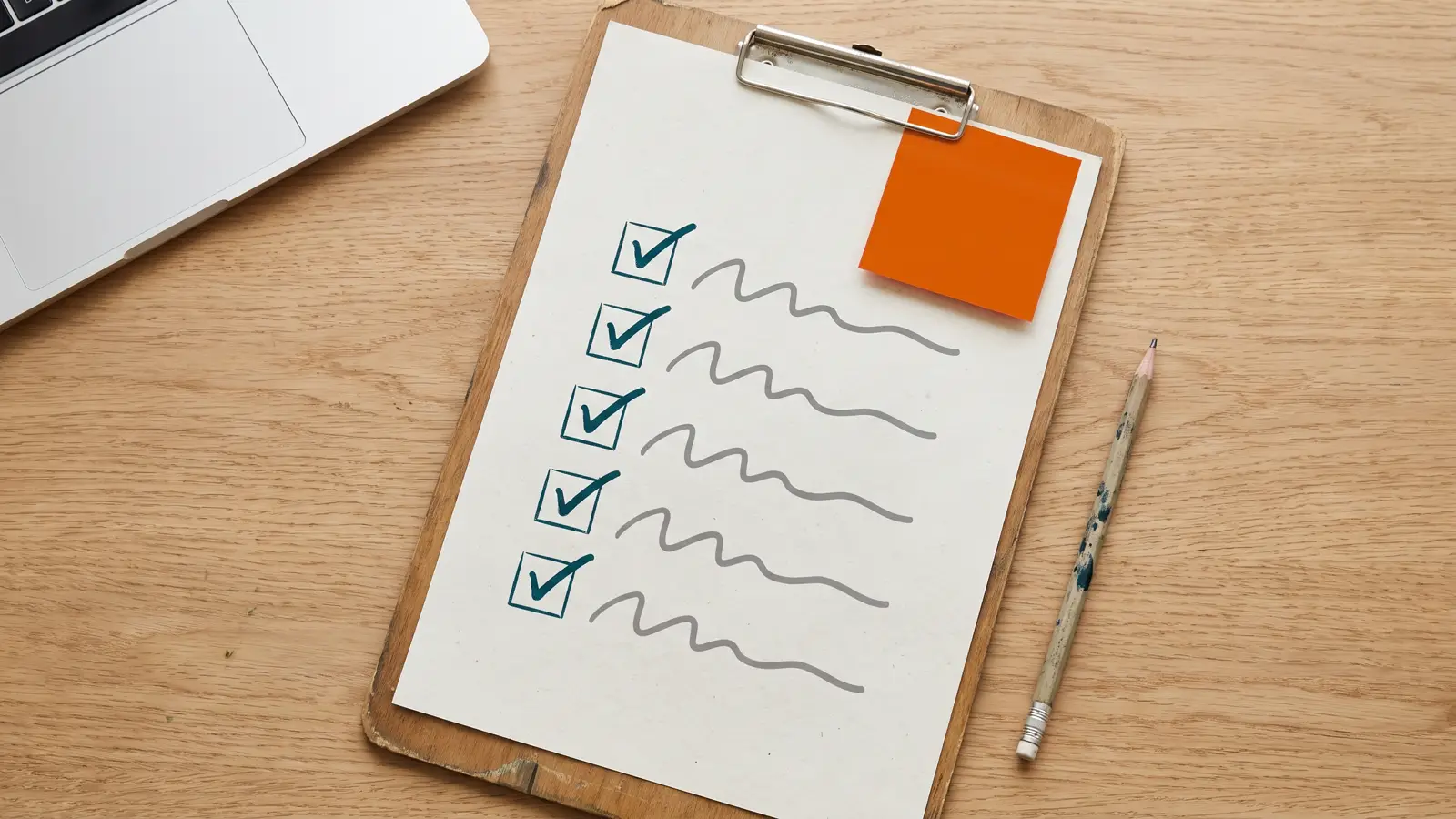 Lista de verificación con cinco puntos tildados sobre un escritorio